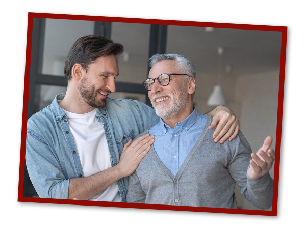 Young adult caucasian son listening and supporting his senior father at home indoors.