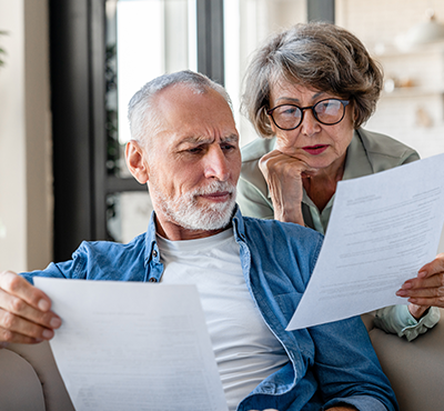Senior spouses reading documents.